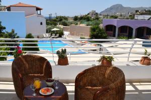 een tafel met eten en drinken op het balkon bij Myrtis Spa Hotel in Plakias