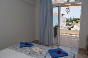 a bedroom with a bed with blue towels and a balcony at Myrtis Spa Hotel in Plakias