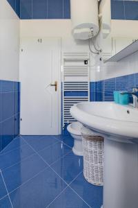 a blue and white bathroom with a sink and a toilet at Villa Tanga in Rovinj