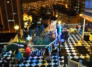 un grupo de personas sentadas en un balcón por la noche en Hotel Brighton, en Valparaíso