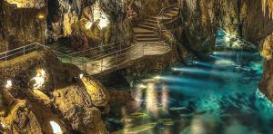 a staircase in a cave with blue water at Apartamentos Turísticos Santa Marina in Aracena