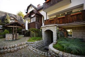a house with a stone walkway in front of a building at Villa Mariano Michałowice in Piechowice