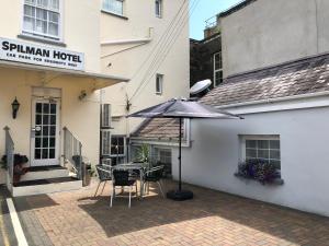 a table with an umbrella in front of a hotel at Spilman Hotel in Carmarthen