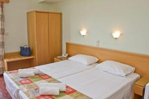 a bedroom with a large bed with two towels on it at Nafsika Hotel in Rhodes Town