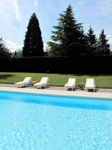 two lounge chairs and a swimming pool with two lounge chairs and a table at Hôtel De La Plage in Amphion les Bains