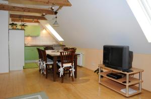 a kitchen and a dining room with a table and a tv at Haus der Sinne in Obernberg am Inn
