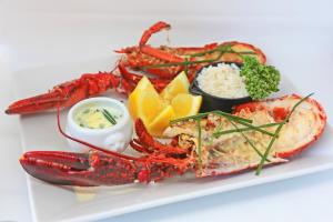 a plate of seafood with a lobster and other foods at Logis Hôtel Le Bellevue in Trévignin