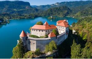 an island in the middle of a lake with a castle at STUDIO LUNA in Bled