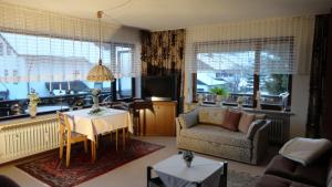 a living room with a table and a couch and a tv at Haus Ritter in Missen-Wilhams