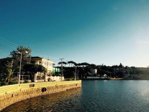 a body of water with a yellow wall and a house at Recanto do Lago Triunfo in Triunfo