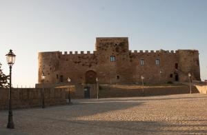 un grande edificio in mattoni con un castello di BORGO PETELIA, Casa Mannarino, suite Lucrezia a Strongoli