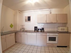 a small kitchen with white cabinets and appliances at Apartment 5 - Maisonette in Heiligenhafen