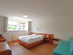 a bedroom with a bed and a chair and a window at Apartment 5 - Maisonette in Heiligenhafen