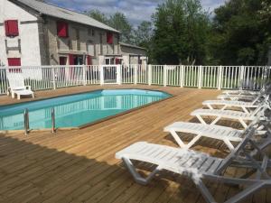 a deck with white chairs and a swimming pool at La Bonne Mine in Le Fraysse