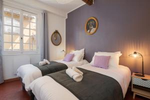 twee bedden in een kamer met paars en wit bij Papa Riviera - Nice Old Town - 2 bedrooms in Nice