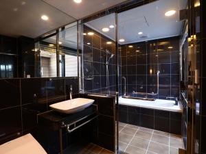 bagno nero con lavandino e vasca di APA Hotel Ningyocho Ekikita a Tokyo Altre 50 foto