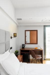 a bedroom with a bed and a desk with a mirror at Athens Odeon Hotel in Athens
