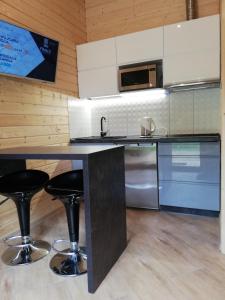a kitchen with a counter with two bar stools at Domek nad morzem in Będzino