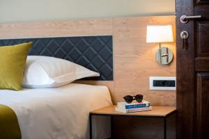 a bedroom with a bed and a nightstand with two glasses on it at Boutique Villa Filaus in Dubrovnik