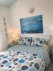 een slaapkamer met een bed met blauwe en witte kussens bij Villa nel villaggio Costa Caddu San Teodoro in San Teodoro