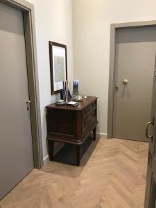 a hallway with a dresser and a mirror and a door at Luigi in Palazzo Bianchi in Parma