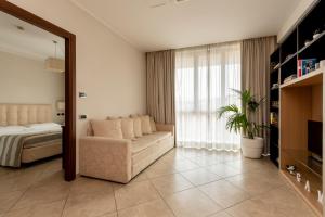 1 dormitorio con sofá, cama y ventana en ApartHotel Anghel en Siena