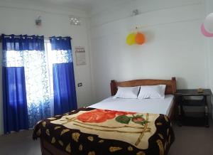 - une chambre avec un lit doté de rideaux bleus dans l'établissement Vamoose Dolma, à Tawang