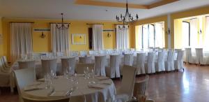 pokój z kilkoma stołami i białymi krzesłami w obiekcie Villa Del Poeta w mieście Arqua Petrarca