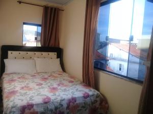 1 dormitorio con cama y ventana con vistas en Apartamentos no centro, en Arraial do Cabo
