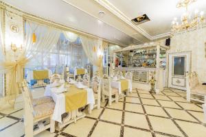 a restaurant with tables and chairs in a room at Hotel Plaza in Anapa