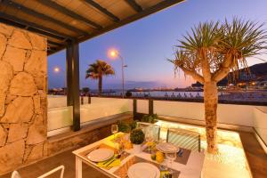 un tavolo su un balcone con palma di BeachFront Suites Morea Puerto Rico by VillaGranCanaria a Puerto Rico de Gran Canaria