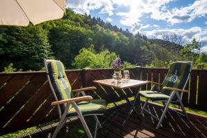 een tafel en stoelen op een terras met uitzicht op een berg bij Ferienwohnung Loft in Schmallenberg