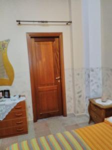 1 dormitorio con puerta de madera y vestidor de madera en AL BORGO VACANZE B&B en Tortora