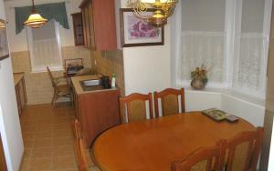 uma cozinha e sala de jantar com uma mesa de madeira e cadeiras em Rowy IV dół em Rowy