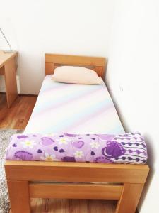 uma cama com uma estrutura de madeira e um colchão roxo em Apartman Marina em Mostar