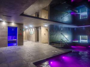 a large bathroom with a hot tub with purple lights at The Kinmel & Kinspa in Abergele