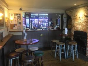 a bar with stools in front of a window at Black Buoy Inn in Wivenhoe