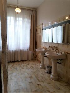 a bathroom with two sinks and a large window at Maison Lalongère in Longueville +28 photos