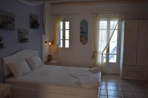 a bedroom with a large white bed in a room at Studios Niovi Serifos in Livadi