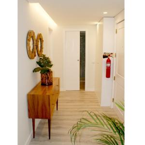 a hallway with a table and a clock on a wall at Apartamento Matosinhos Mar in Matosinhos