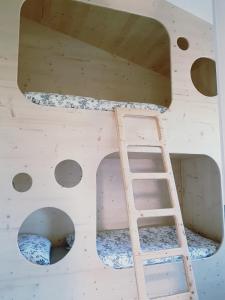 a wooden bunk bed with a ladder in a room at Heimatliebe Ferienwohnung in Börgerende-Rethwisch