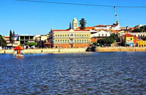 a person in a chair in the water near a city at Recanto do Lago Triunfo in Triunfo