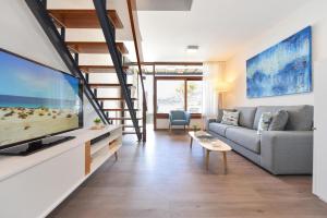 un soggiorno con divano e TV a schermo piatto di BeachFront Suites Morea Puerto Rico by VillaGranCanaria a Puerto Rico de Gran Canaria
