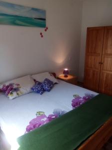 Un dormitorio con una cama con flores púrpuras. en KUŽINIĆI, en Divšići