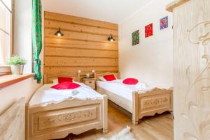 a bedroom with two beds and a window at Apartamenty Osada Gubałówka Zakopane in Zakopane