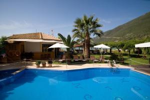 a large blue swimming pool in front of a house at Nefeli Wind Club in Vasiliki