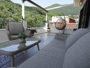 a porch with a couch and a table on a balcony at Zorbas Apartments in Parga