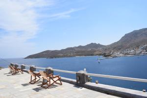 a row of chairs sitting on a pier near the water at Studios Niovi Serifos in Livadi