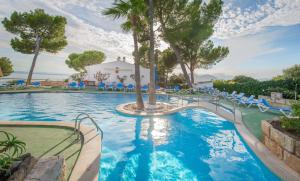 a swimming pool filled with lots of blue water at Aparthotel Ona Aucanada in Port d'Alcudia