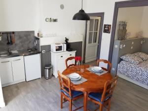 uma cozinha com mesa e cadeiras num quarto em l'Avant Garde, dormir dans un bâtiment classé au patrimoine mondial de l'UNESCO em Blaye